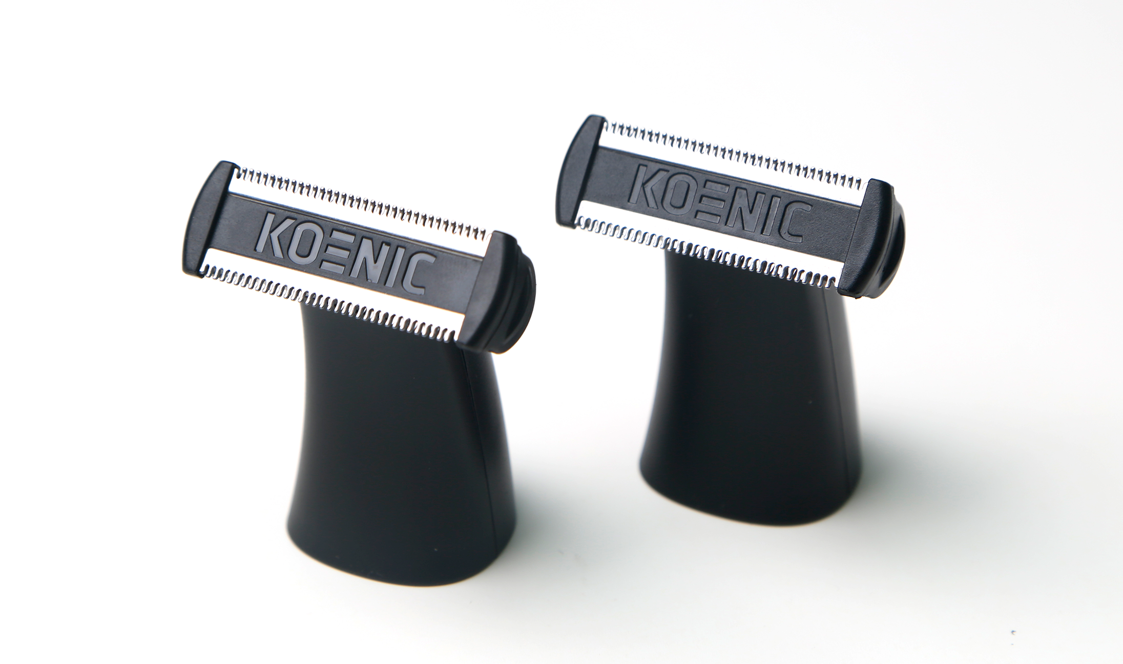 Dwa czarne nasadki maszynki do golenia Koenic na białym tle.