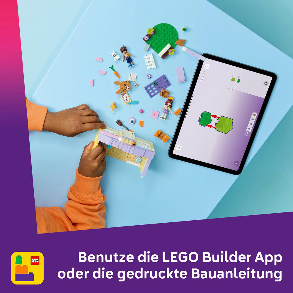 Kind baut mit LEGO auf einem blauen Tisch, daneben ein Tablet mit Bauanleitung.