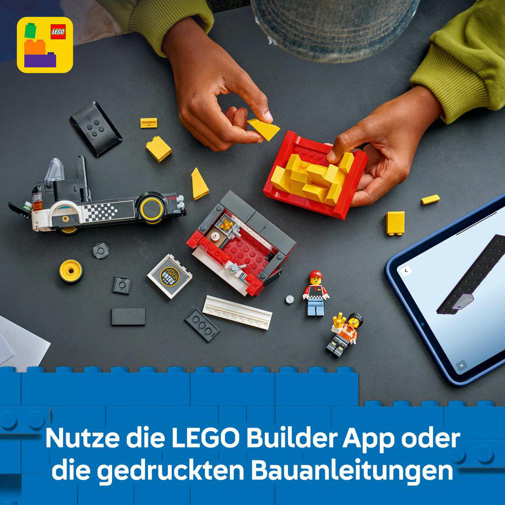 Hände bauen mit Lego-Steinen, eine Bauanleitung auf einem Tablet ist zu sehen.