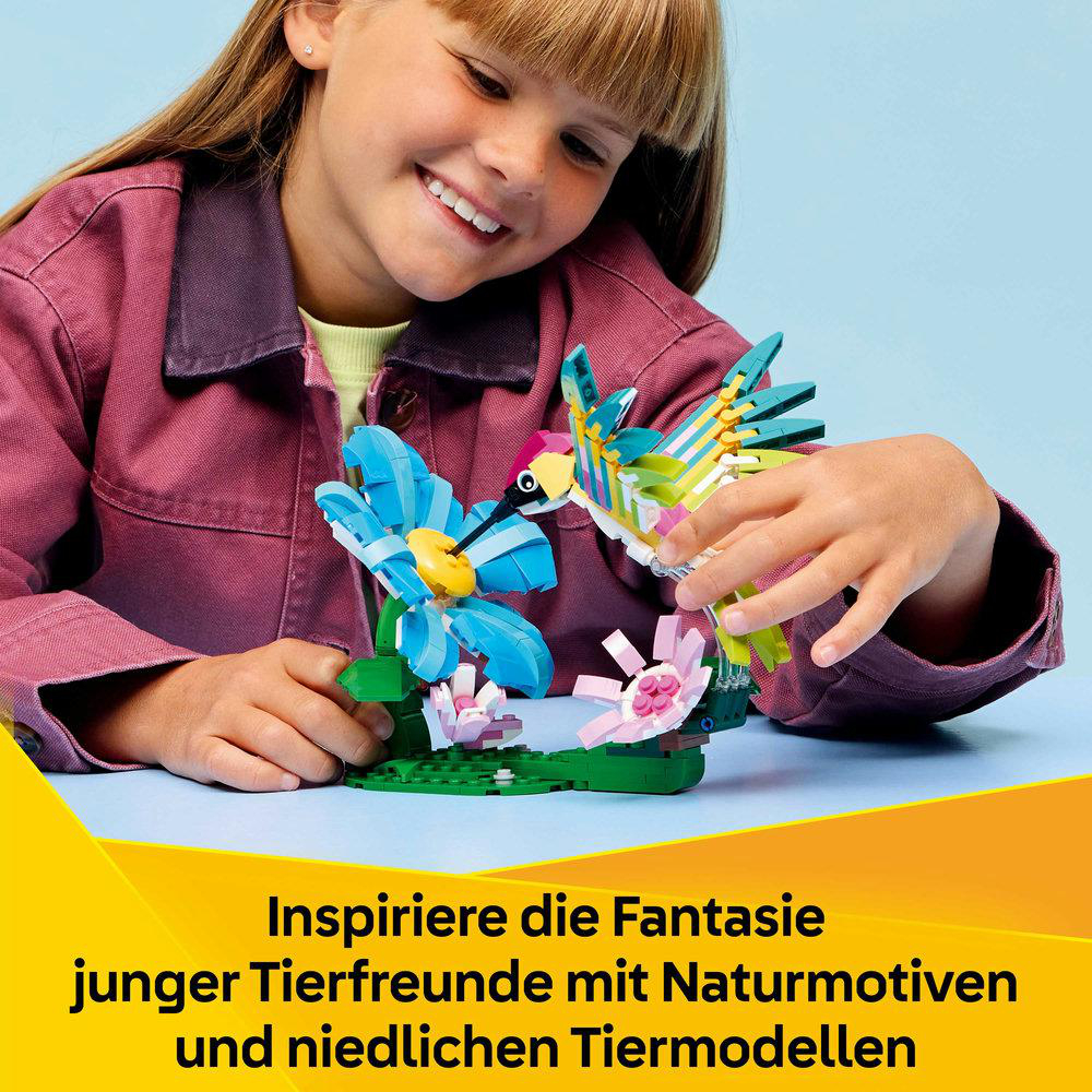 Ein Mädchen baut ein buntes Vogel- und Blumen-LEGO-Set. Sie lächelt.