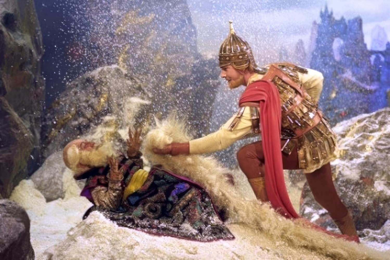 Ein Mann in Rüstung hilft einer Figur, die in Schnee und Fell gehüllt ist.