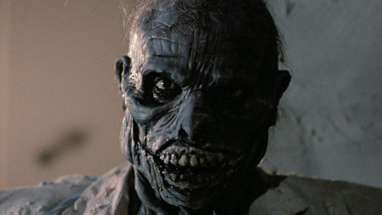 Ein gruseliges, blauhäutiges Monster mit zerfallenem Gesicht und offenen Mund.