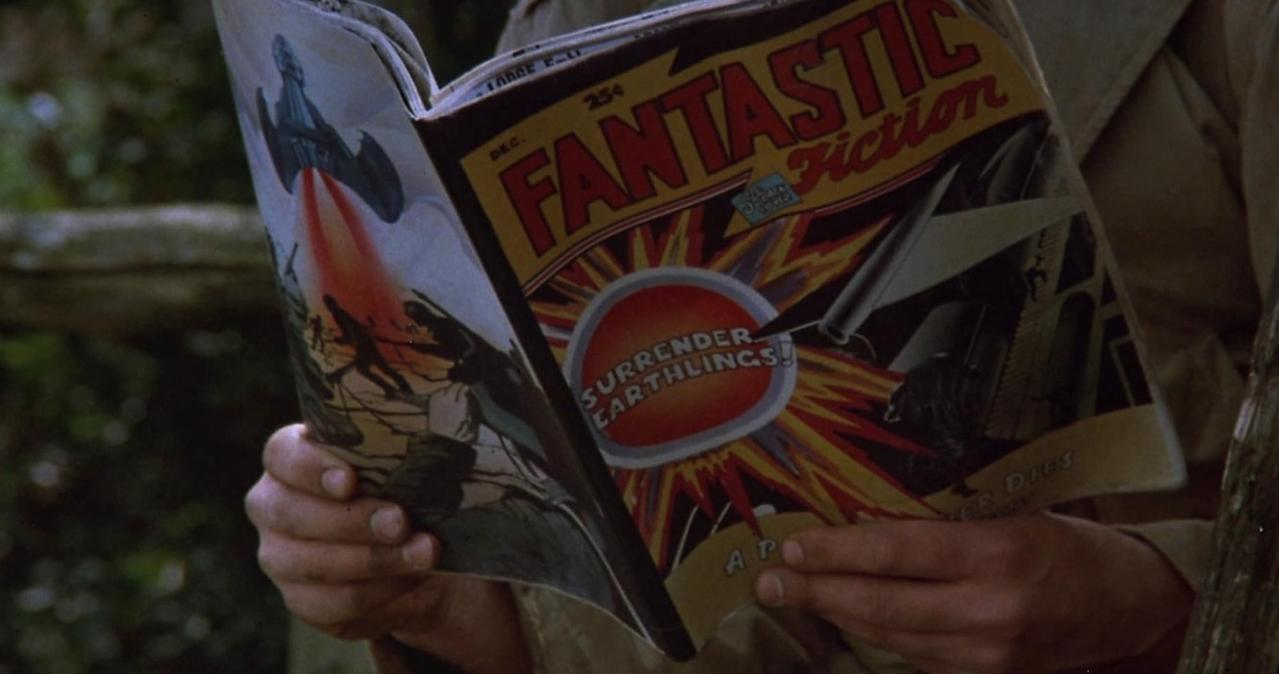 Eine Person liest ein "Fantastic Fiction" Magazin mit Aliens und Raketen.
