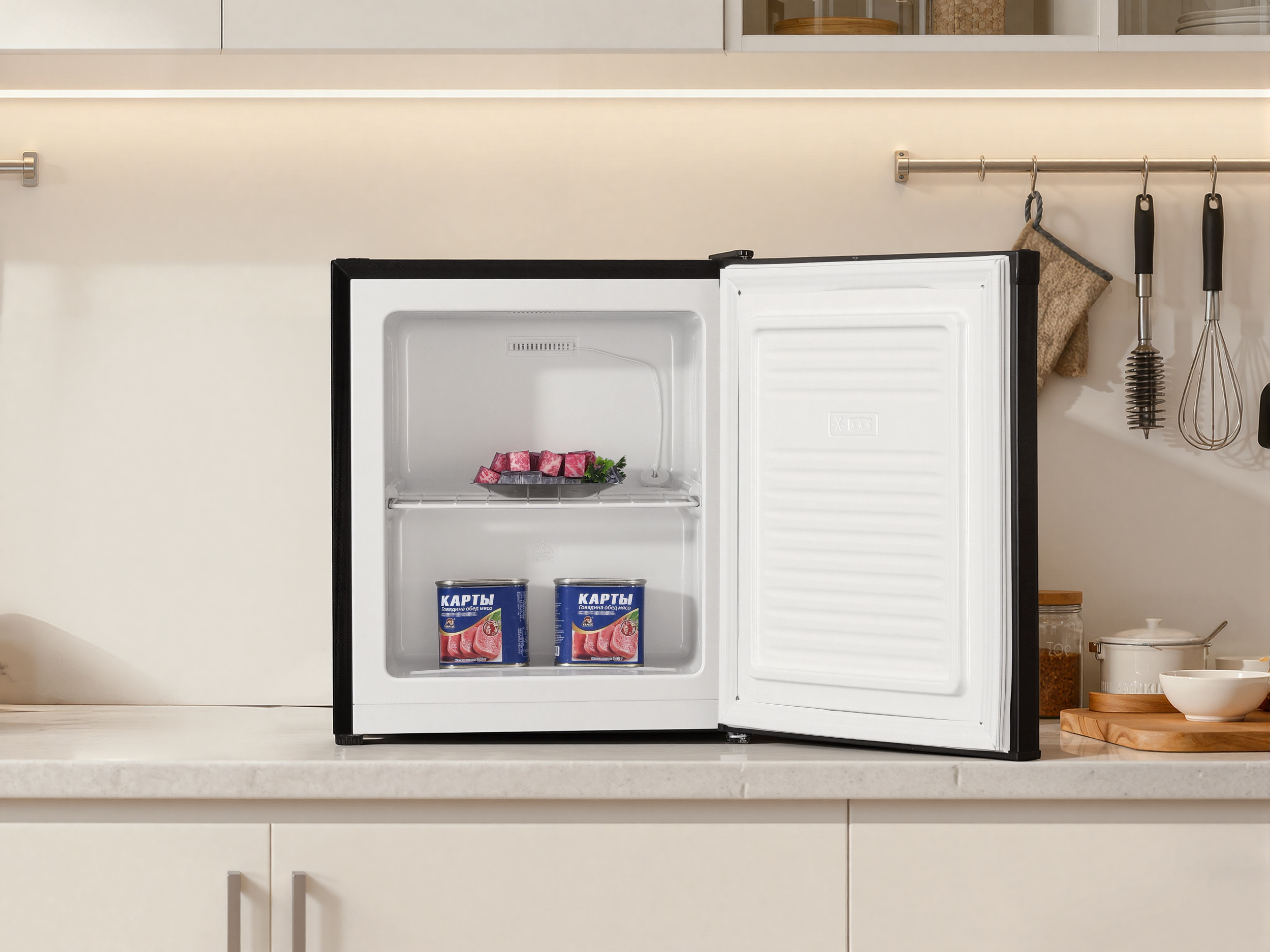 Ein offener schwarzer Kühlschrank mit Fleischwürfeln und Konserven darin.