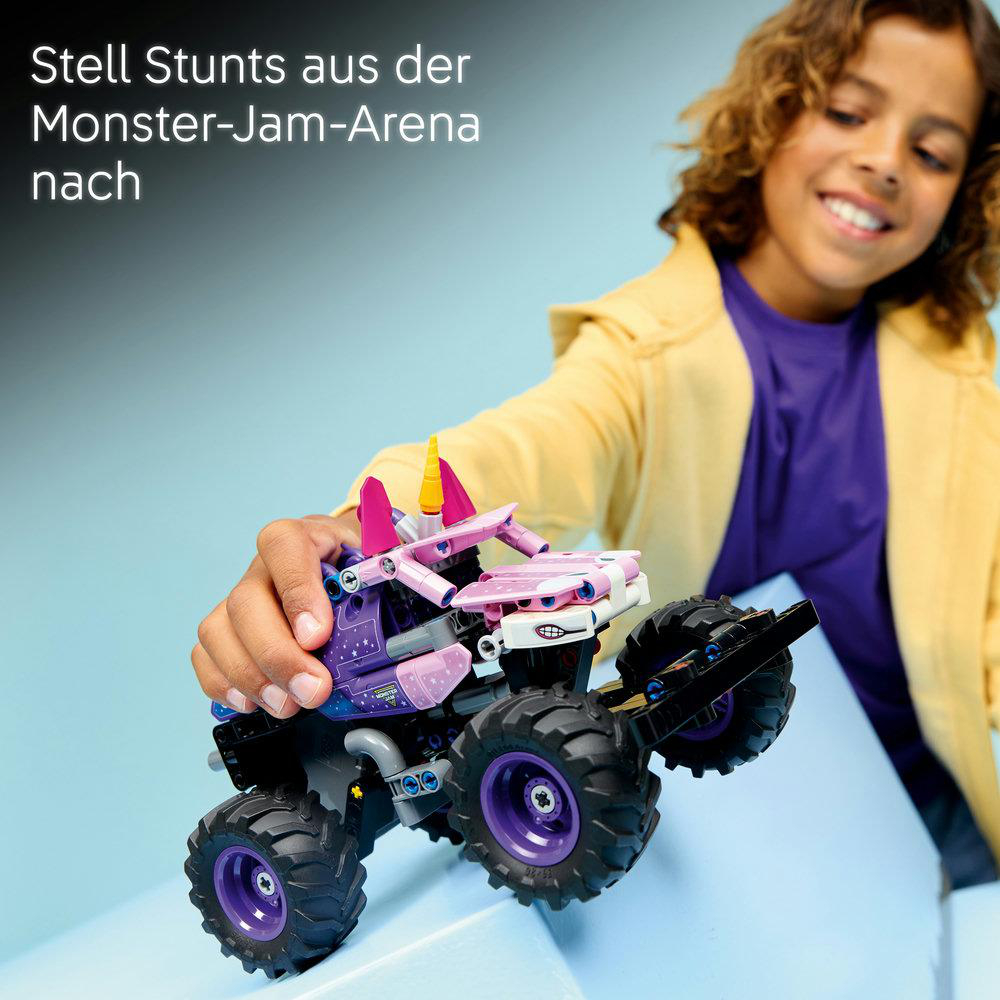 Ein Kind hält ein lila Monster-Truck-Spielzeug mit rosa Verzierungen und Hörnern.