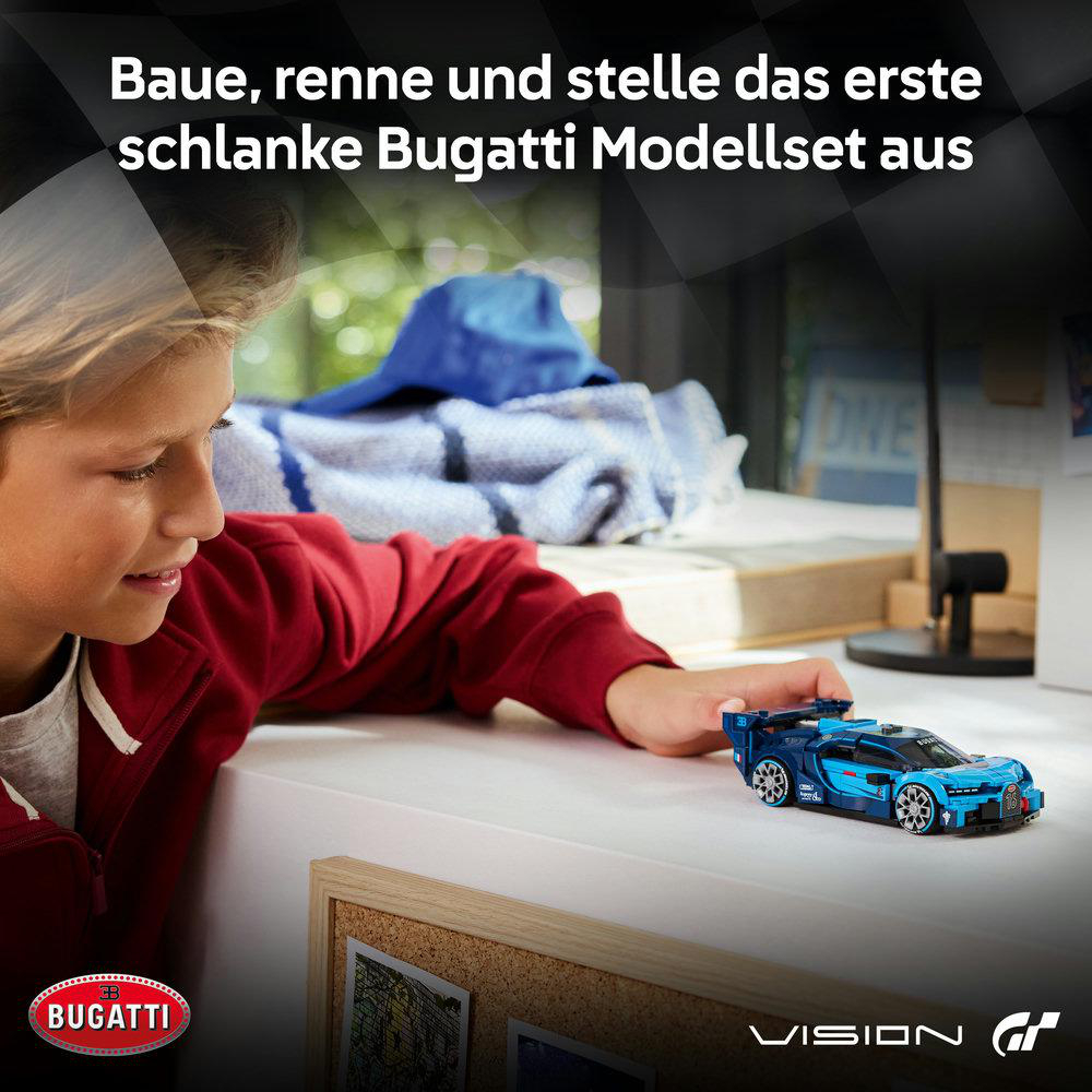 Ein Junge spielt mit einem blauen Bugatti Spielzeugauto auf einem Tisch.
