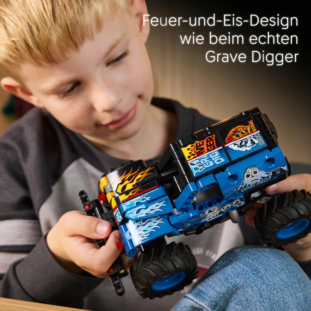 Ein Junge hält einen blauen Lego-Monster-Truck mit Flammen- und Eismotiv.