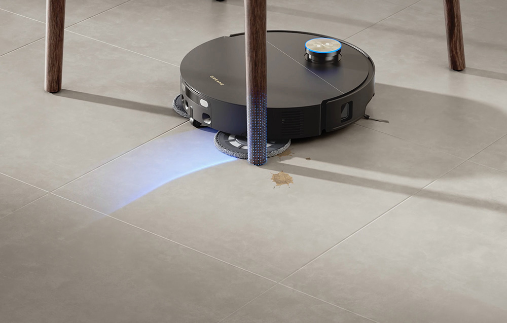 Robot sprzątający czyści brudną podłogę, pozostawiając niebieski ślad światła.