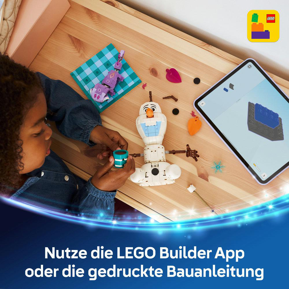 Ein Kind baut einen Schneemann aus LEGO-Steinen, eine App zeigt die Anleitung.