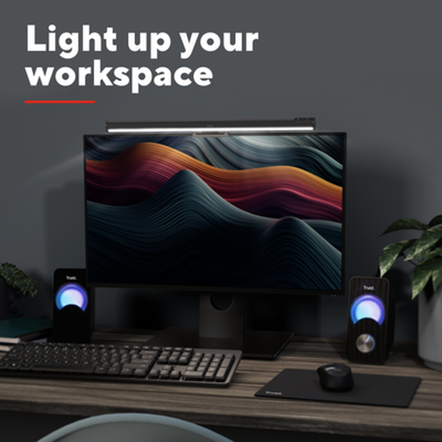 A desk setup with a monitor, keyboard, mouse, and speakers.
