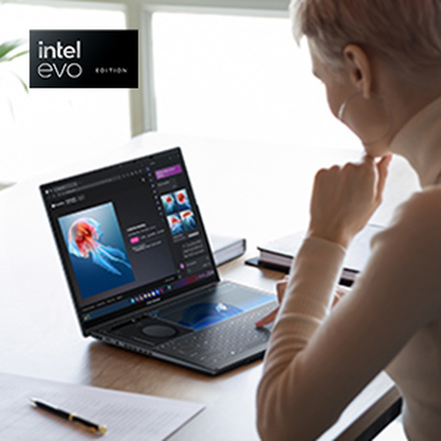 A person uses a laptop with Intel Evo logo. A jellyfish image is displayed on the screen.