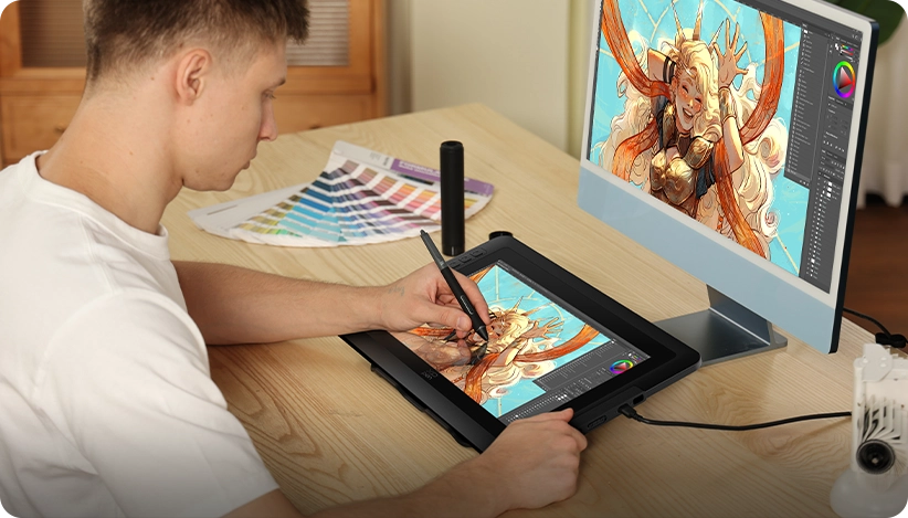 Un uomo disegna digitalmente su un tablet, accanto a un monitor che mostra arte.