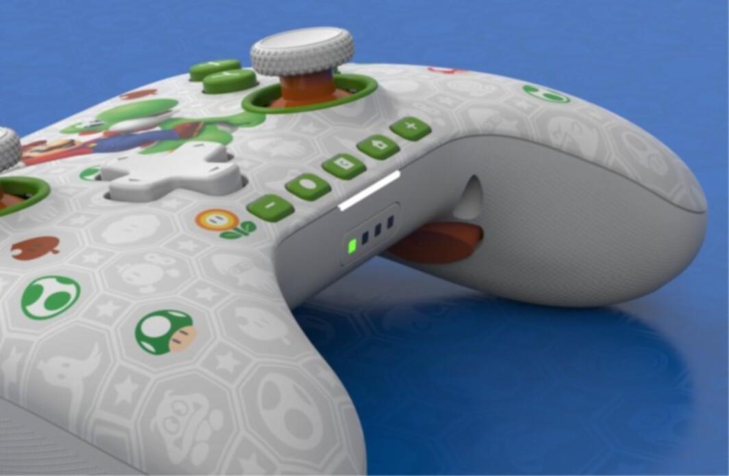 Ein weißer Controller mit Mario-Motiven und grünen Tasten auf blauem Hintergrund.