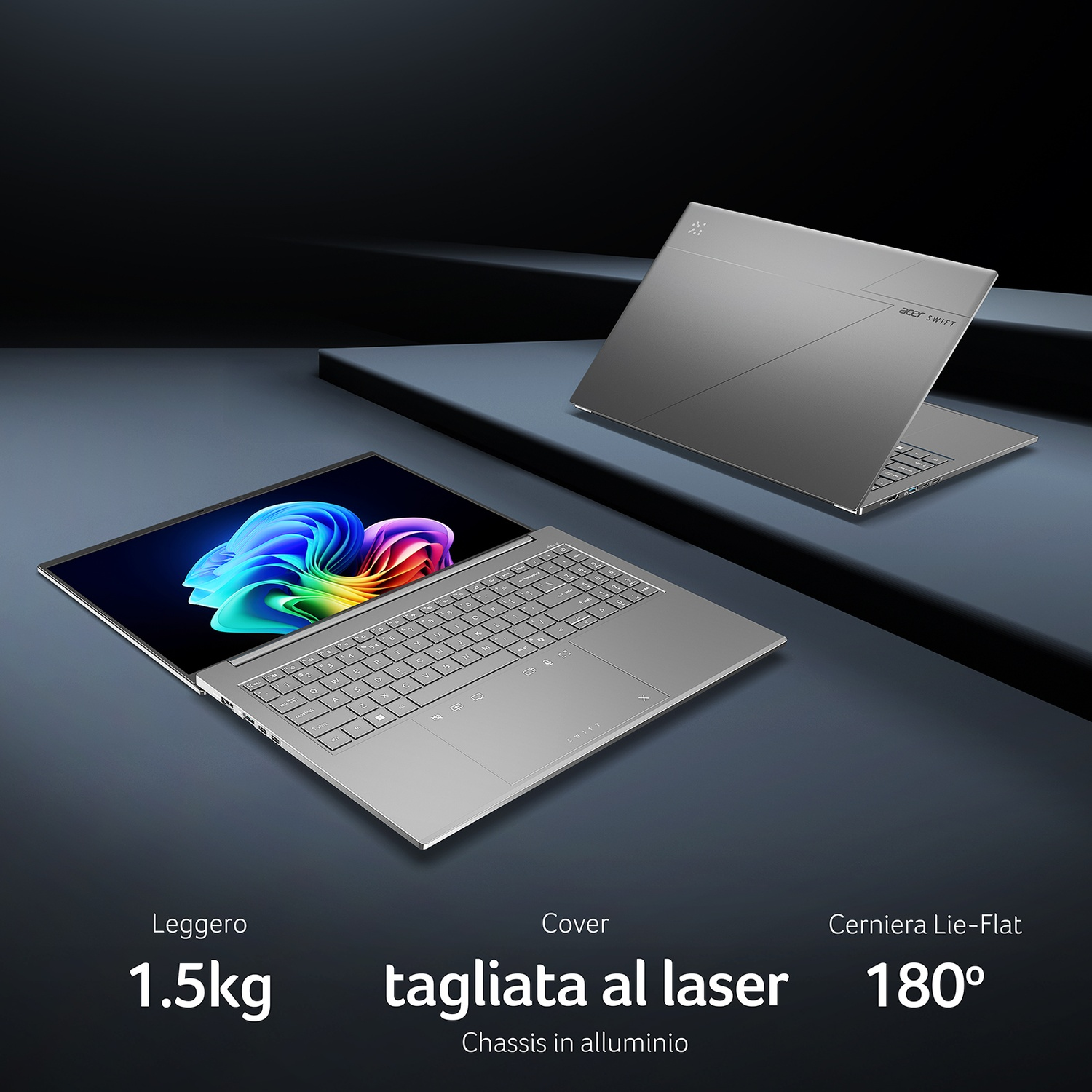 Un laptop argento con schermo e tastiera illuminati su sfondo scuro.