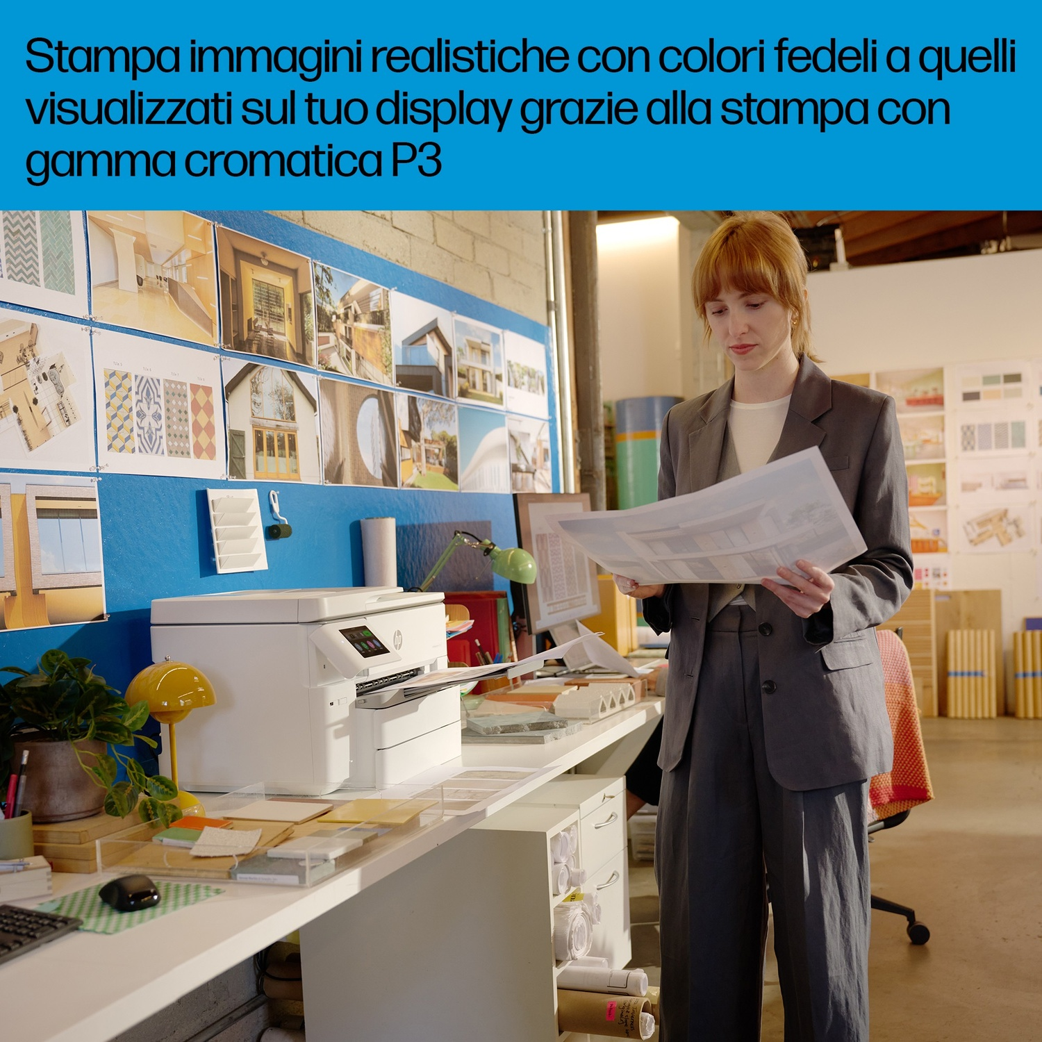 Una donna in un ufficio esamina documenti accanto a una stampante e molte immagini.