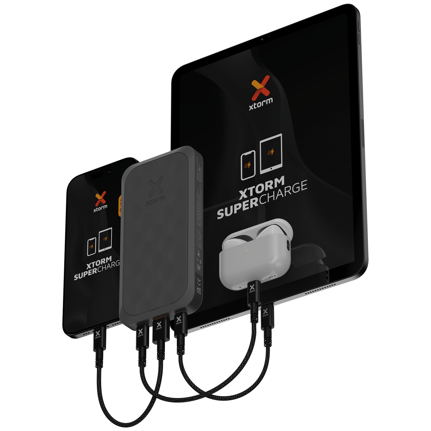 Une power bank Xtorm noire charge un smartphone, une tablette et des écouteurs.