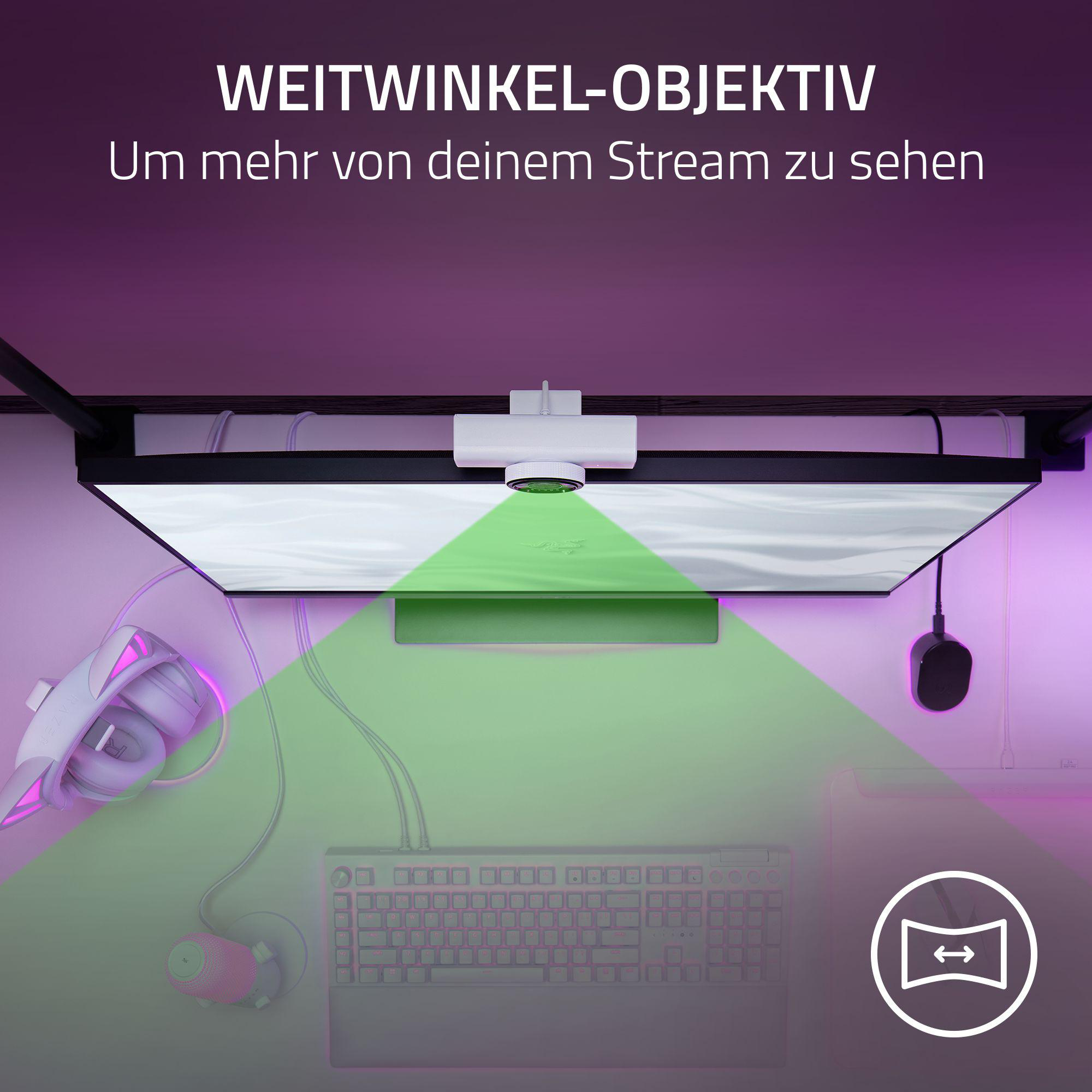 Ein Gaming-Setup mit breitem Monitor, Tastatur, Maus, Kopfhörern und einer Kamera.