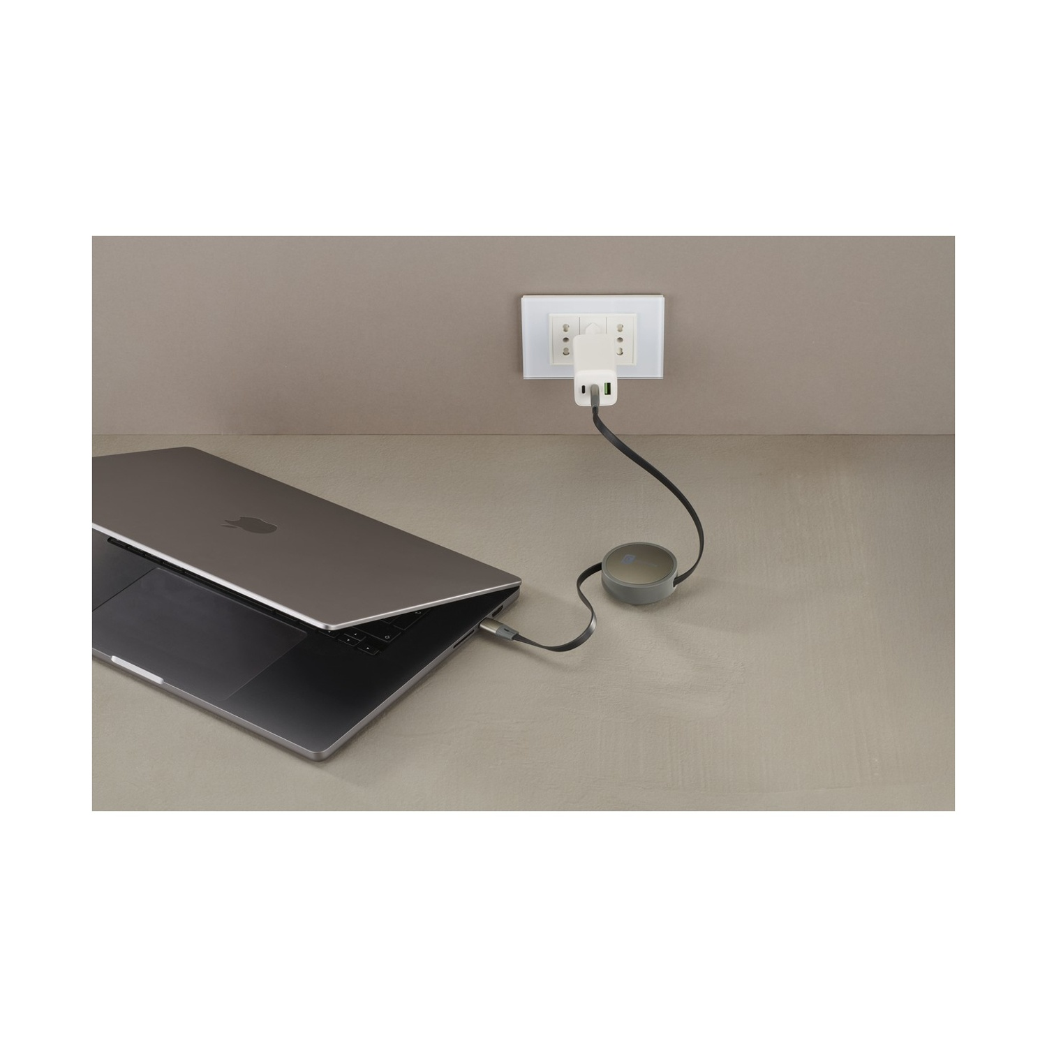 Un laptop è collegato a una presa a muro con un adattatore.
