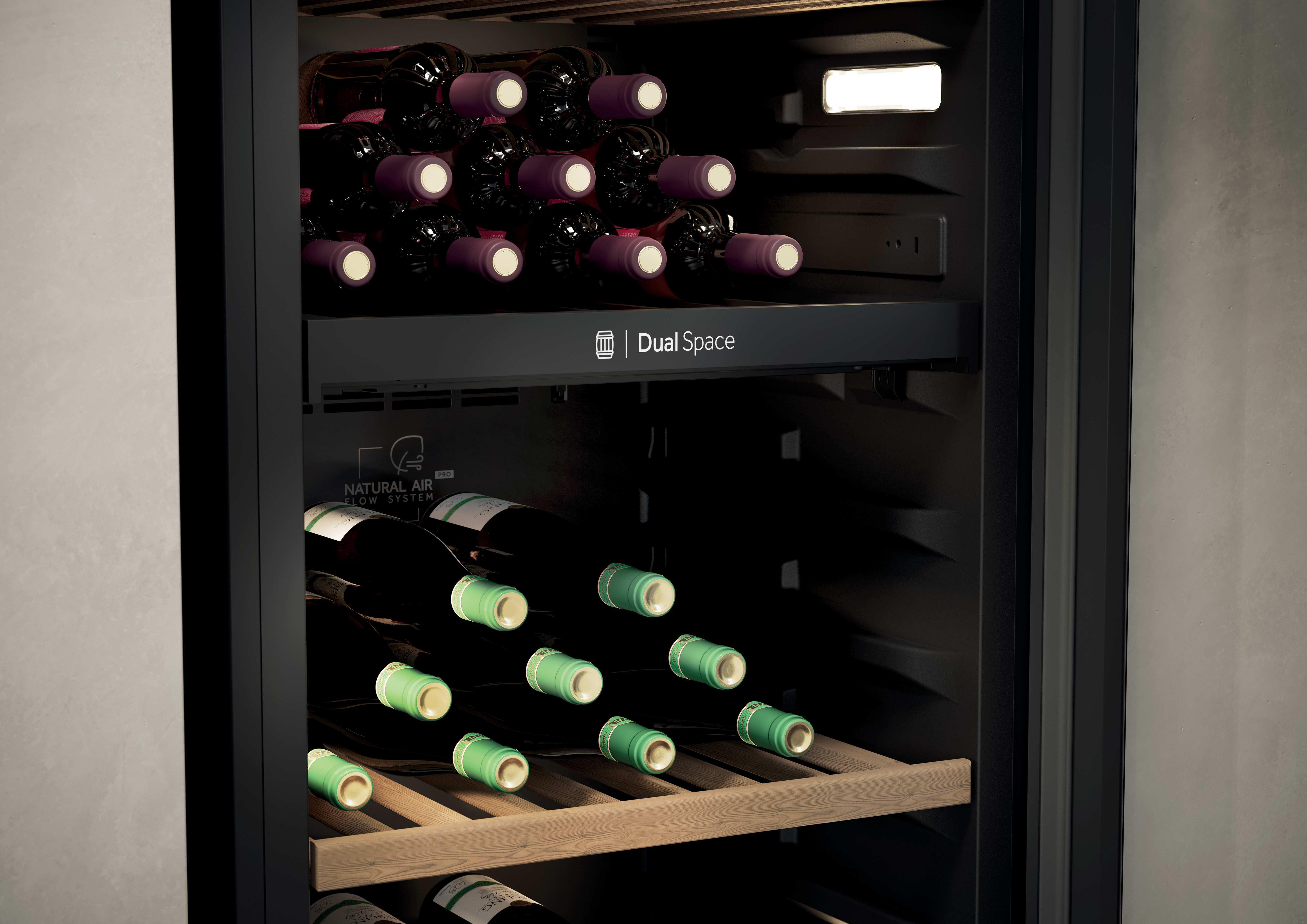 Ein Weinkühlschrank mit zwei Ebenen, gefüllt mit dunklen und grünen Flaschen.