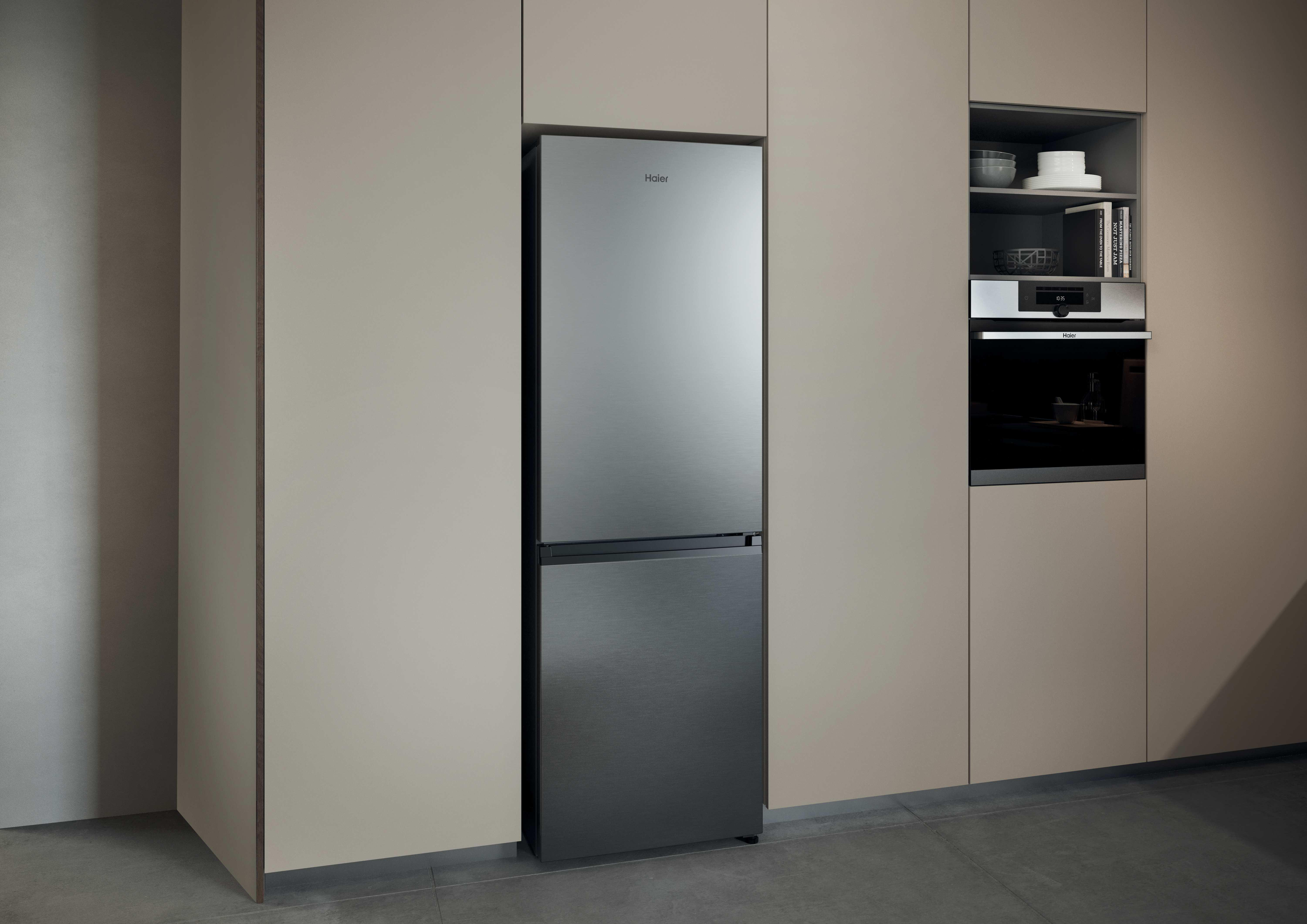 Moderner Haier Kühlschrank und Einbauofen in einer Küche mit beigefarbenen Schränken.