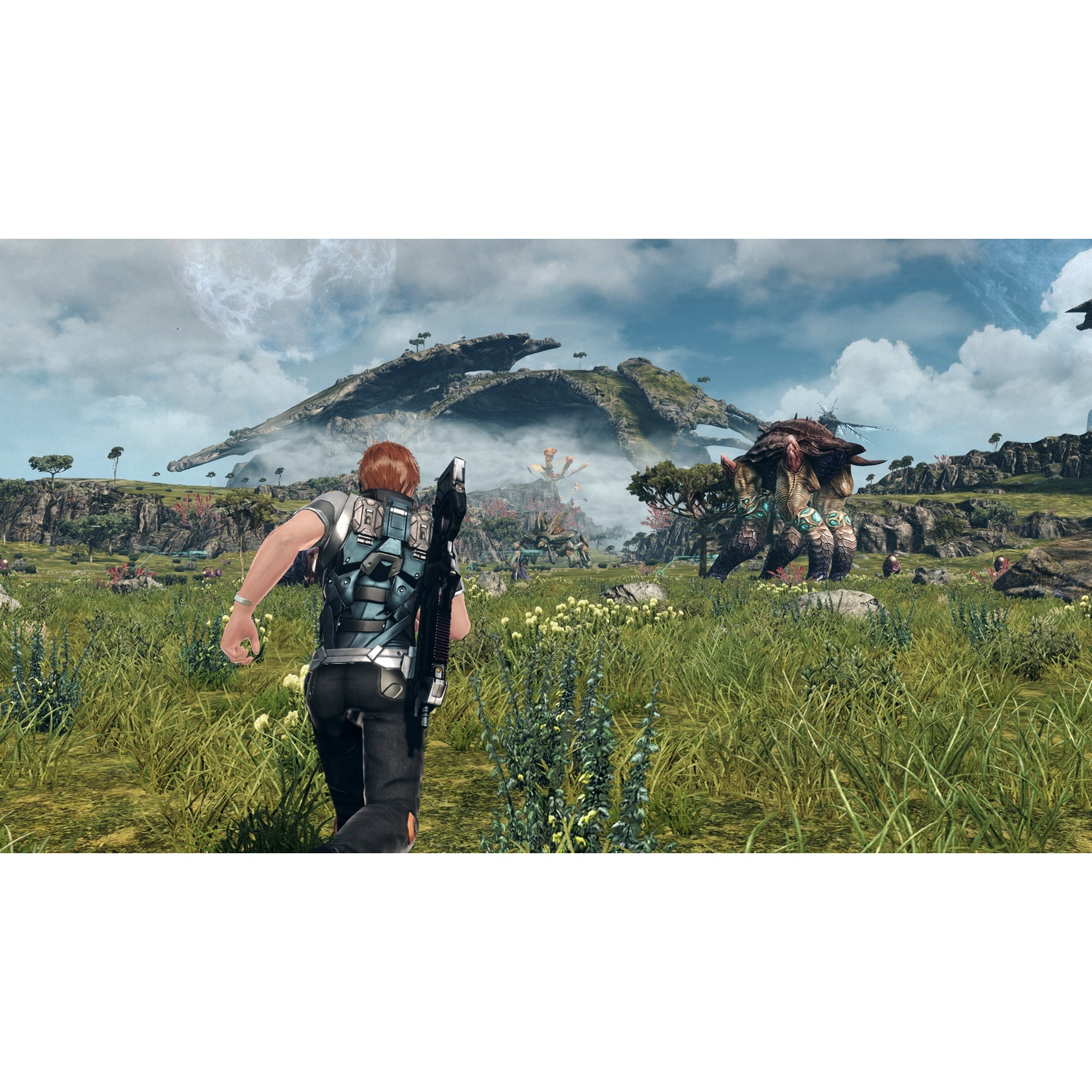 A player runs through tall grass towards a giant armored creature.