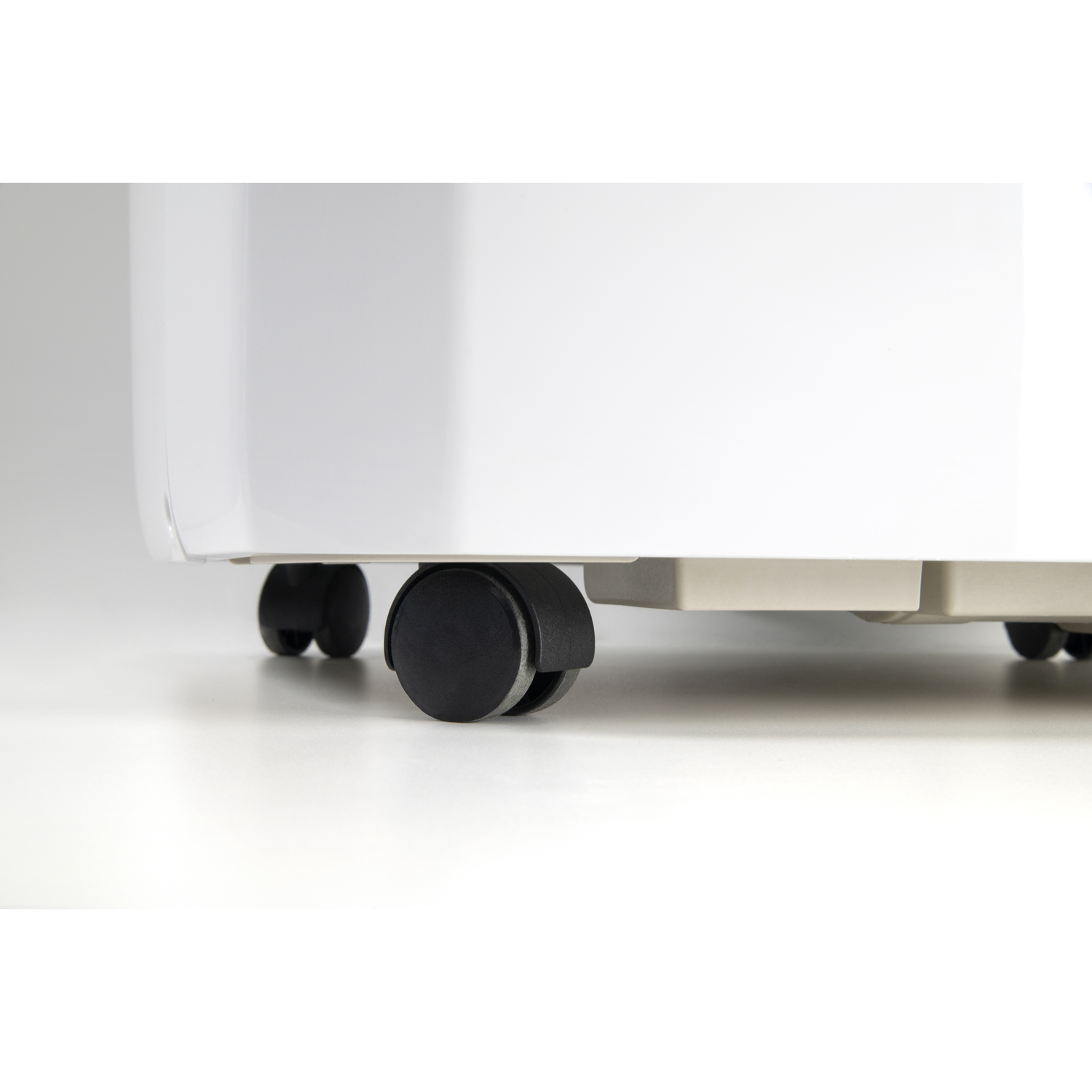 Close-up of black casters on a white appliance against a light background.