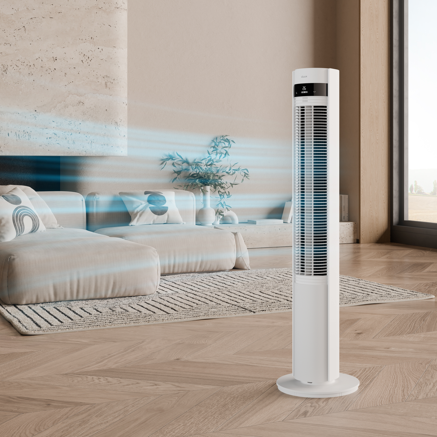 A white tower fan stands in a modern living room next to a sofa.