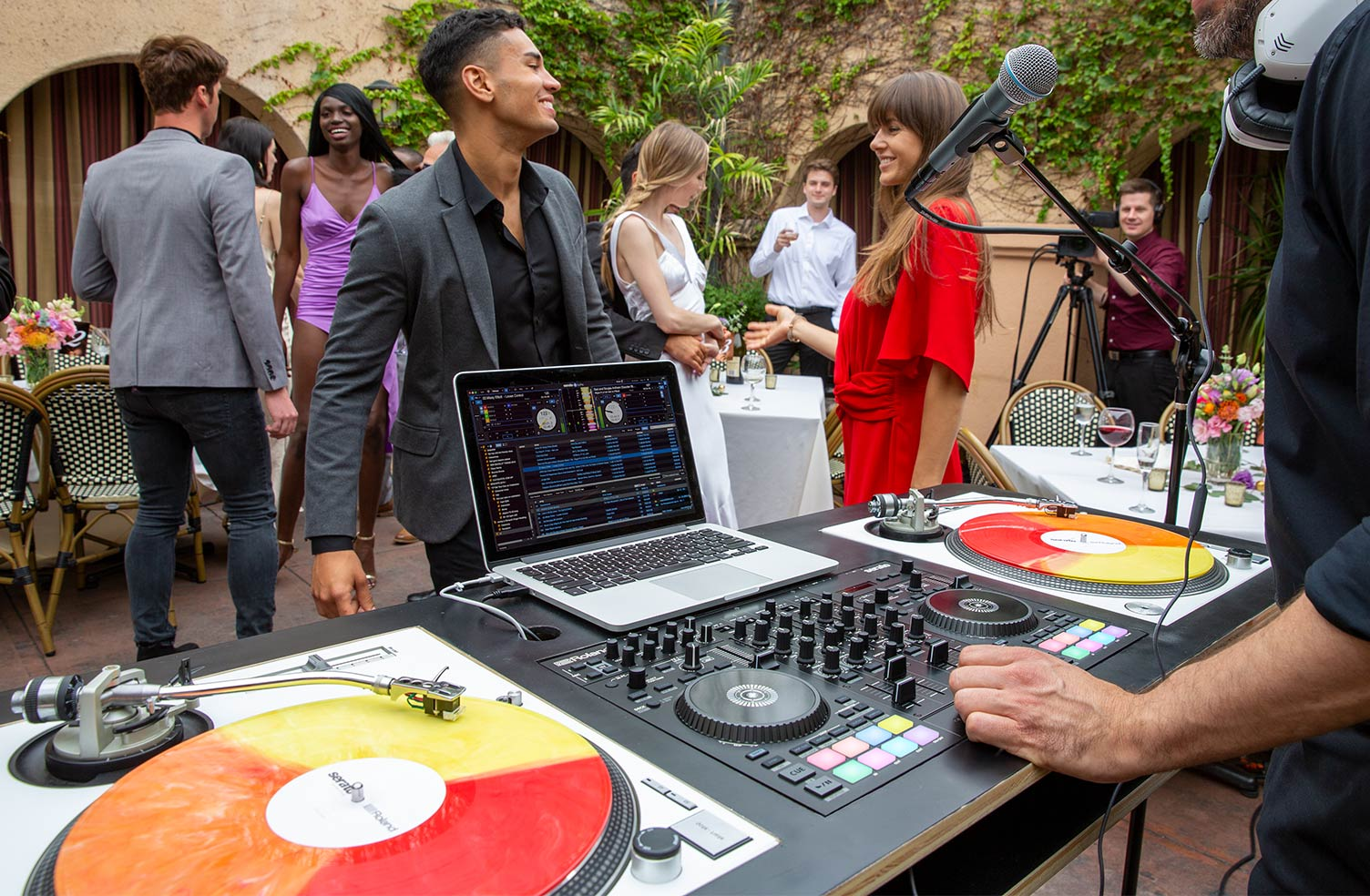 DJ-Ausrüstung mit Plattenspielern, Laptop und Mischpult bei einer Veranstaltung im Freien.