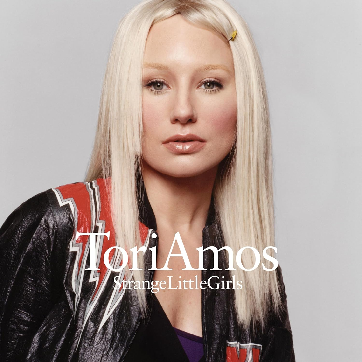 Tori Amos fekete bőrdzsekit visel piros csíkokkal. Szőke haja van.