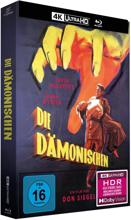 Ein Mann trägt eine Frau. Eine riesige gelbe Hand greift von oben. "Die Dämonischen" 4K UHD.
