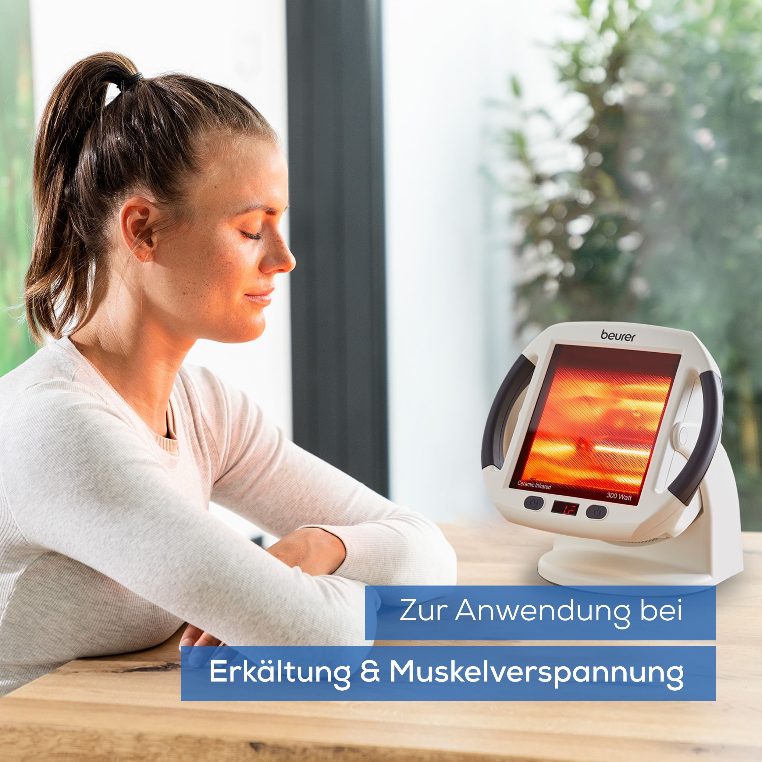 Frau sitzt vor Wärmelampe, die auf Erkältung & Muskelverspannungen abzielt.