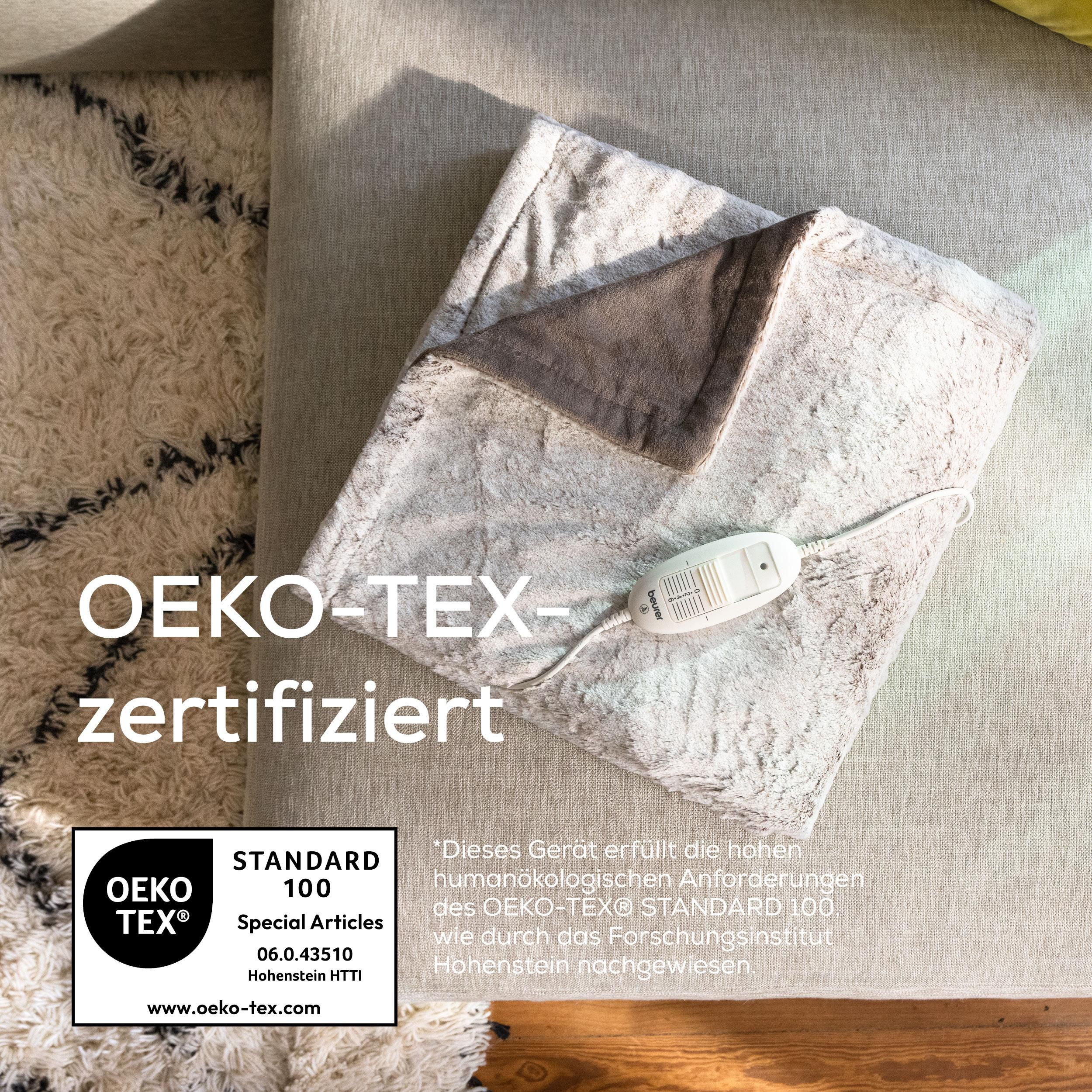 Ein flauschiges, weißes Heizkissen mit Bedienelement und OEKO-TEX-Zertifizierung.