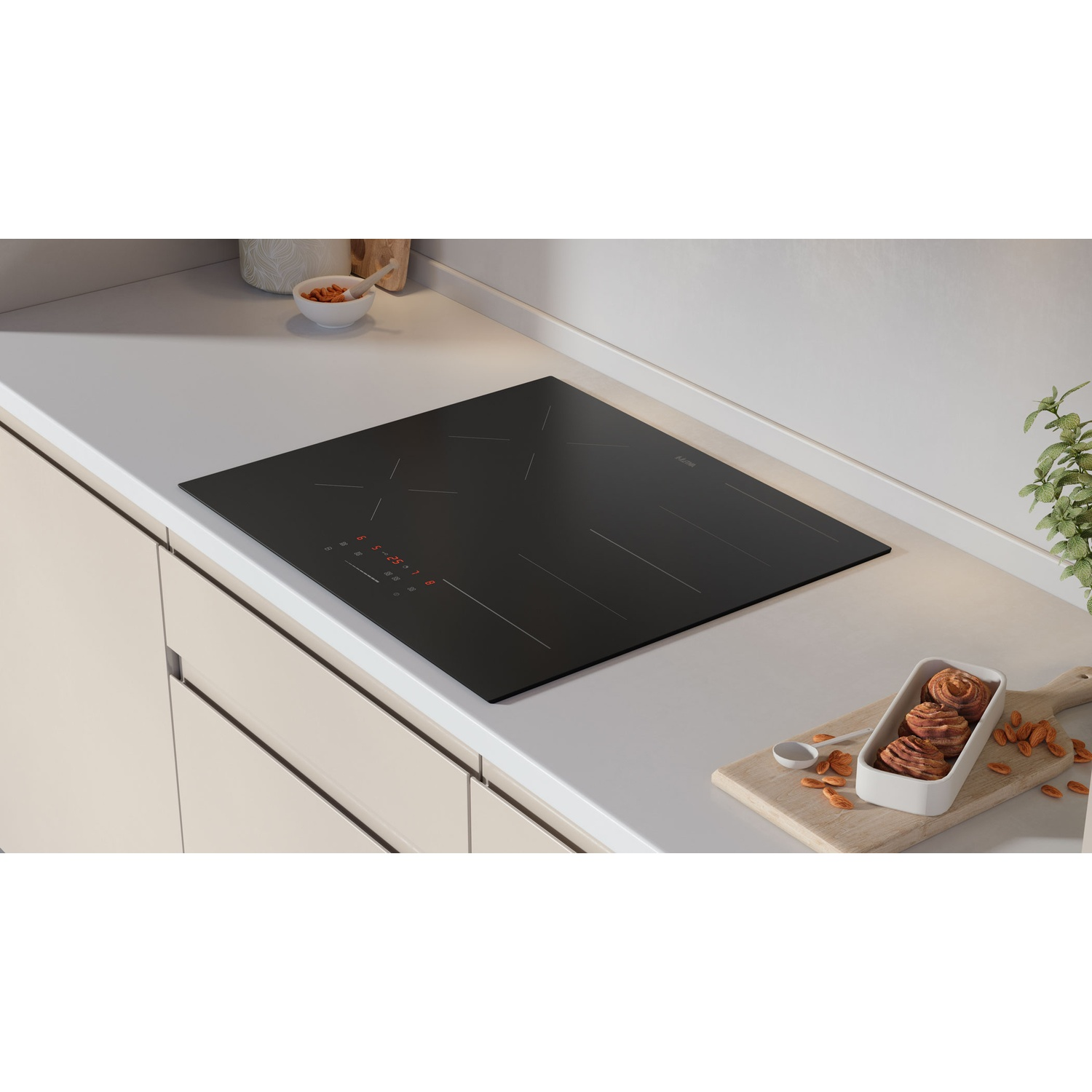 Plaque à induction noire avec chiffres rouges sur un plan de travail avec pâtisseries.