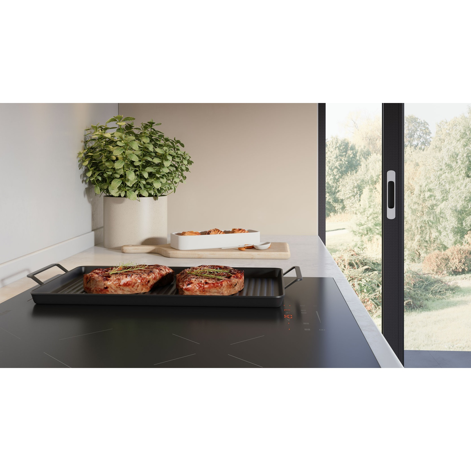 Deux steaks sur une poêle-gril sur une plaque à induction, avec une plante et une fenêtre à l'arrière.