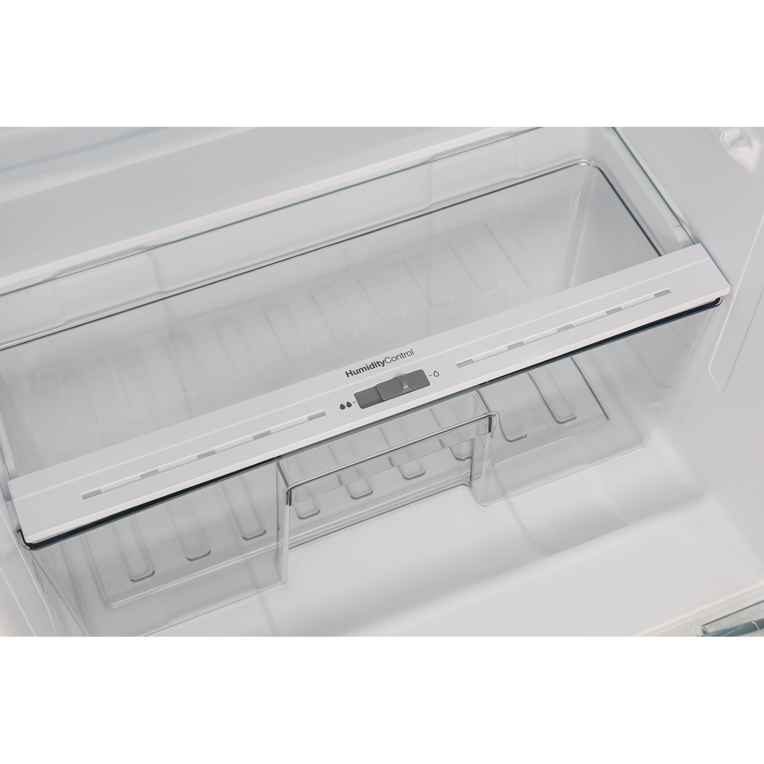 Un réfrigérateur vide avec un tiroir transparent et contrôle d'humidité.