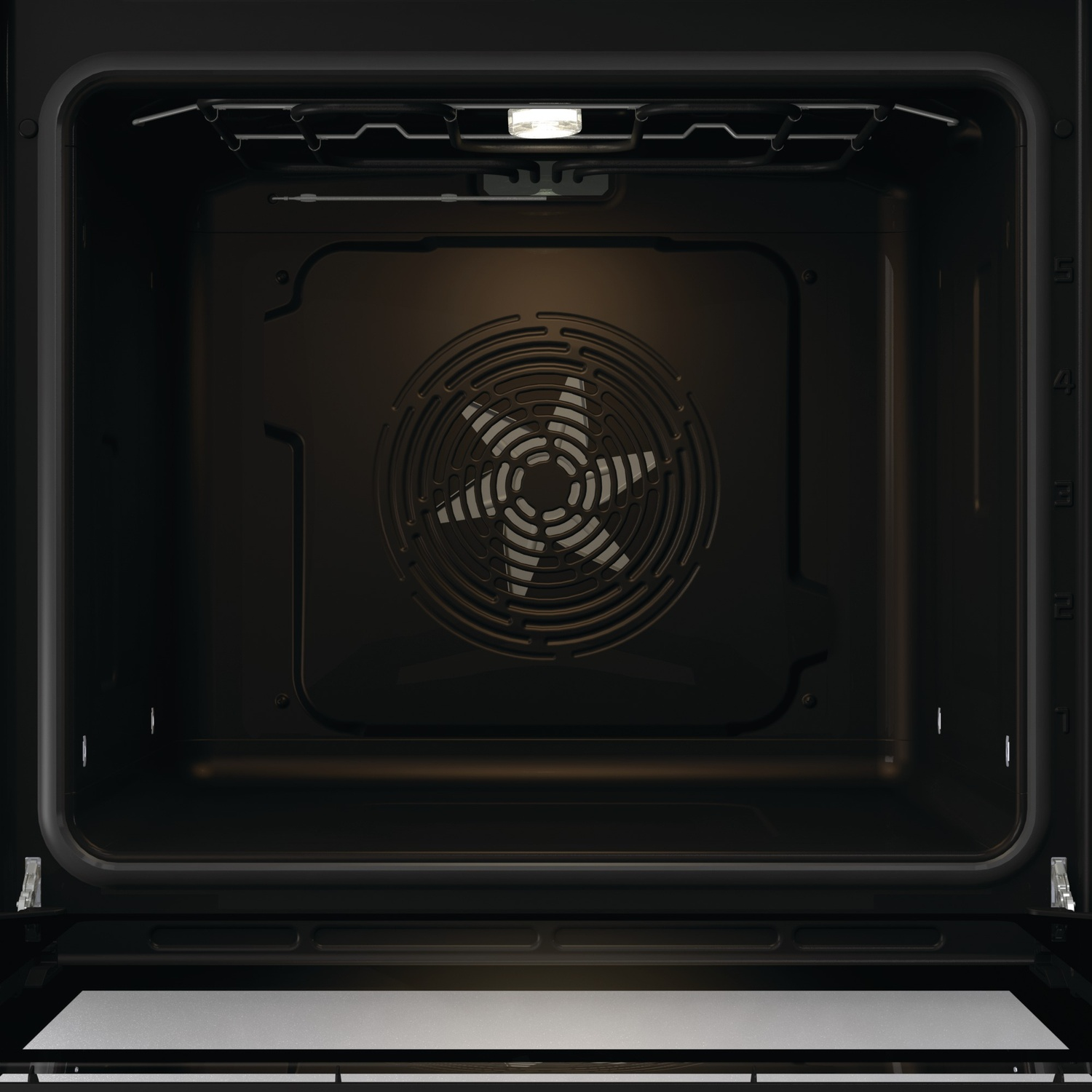 Interieur van een donkere oven met ventilator en licht.