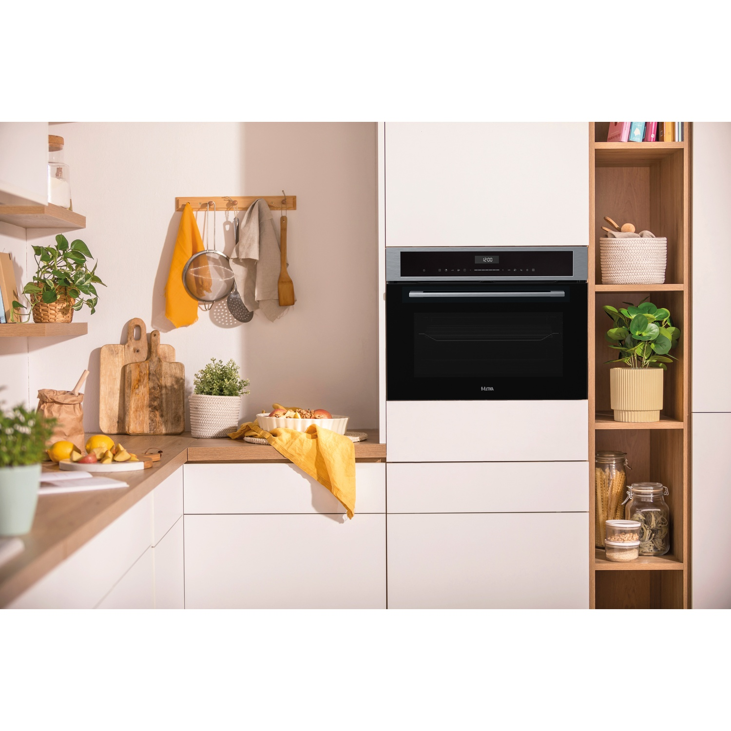Modern kitchen with built-in oven, wooden shelves, and kitchenware.