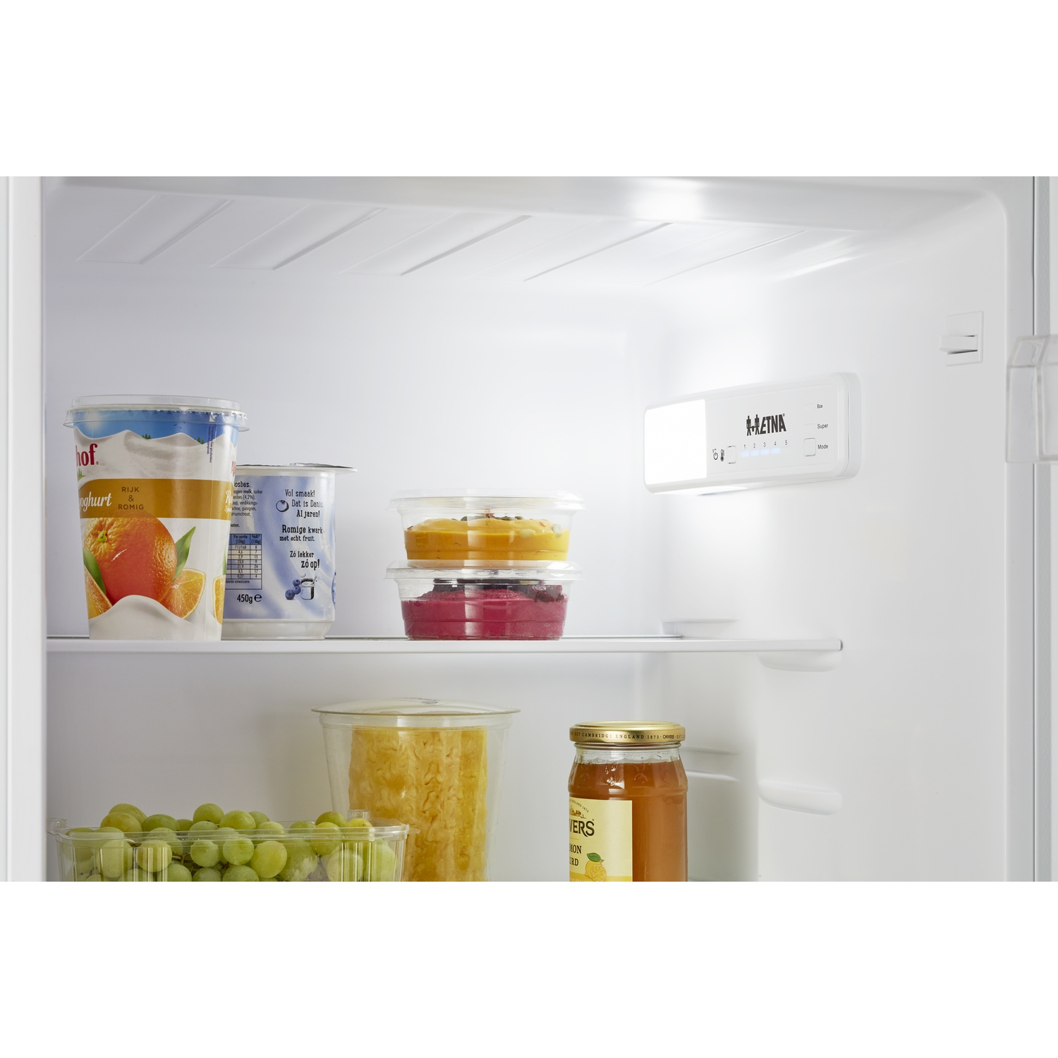 Refrigerator interior with yogurt, grapes, jam, and a digital control panel.