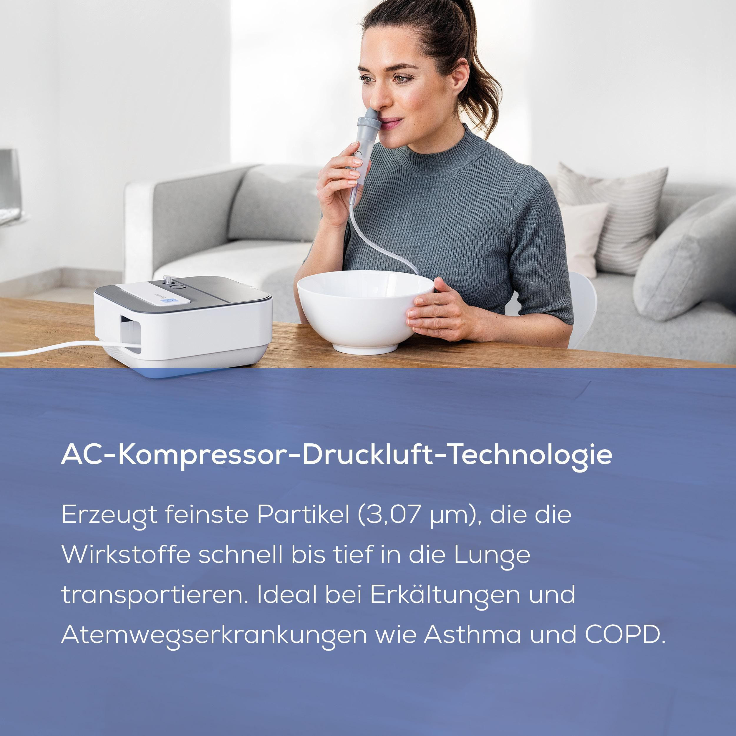 Frau mit Vernebler im Raum. Ein Inhalator steht auf dem Tisch.