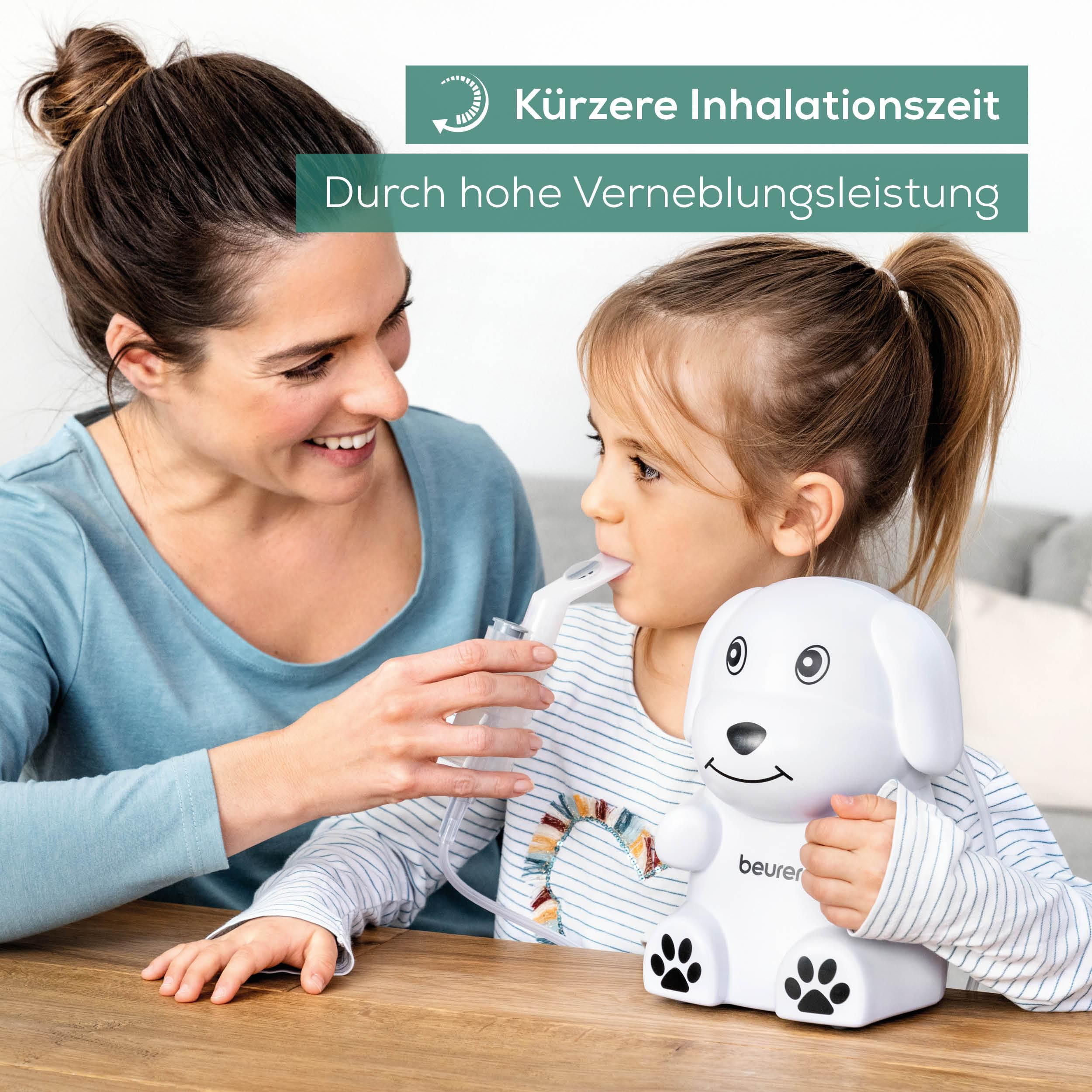 Mutter hilft Kind bei Inhalator in Hundeform auf einem Holztisch.