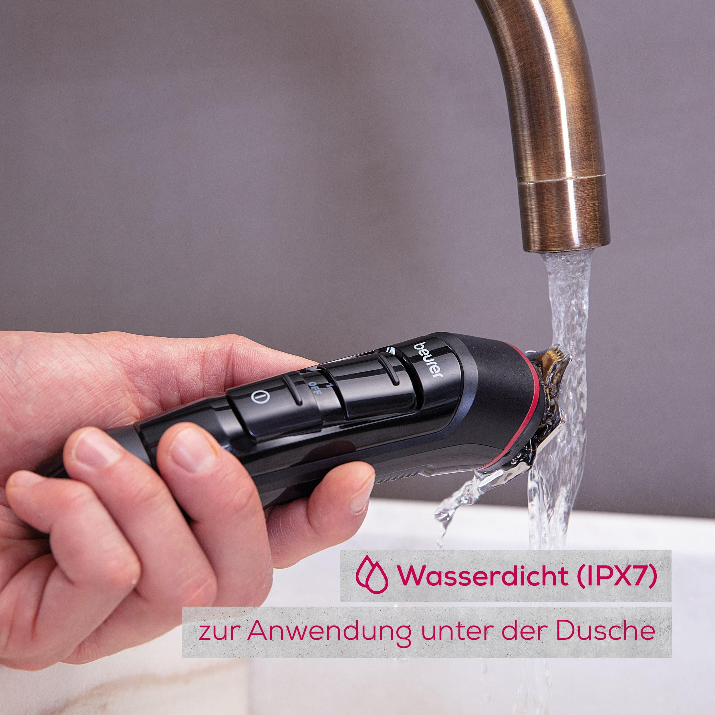 Ein schwarzer Trimmer wird unter fließendem Wasser gehalten. Wasserdicht (IPX7).