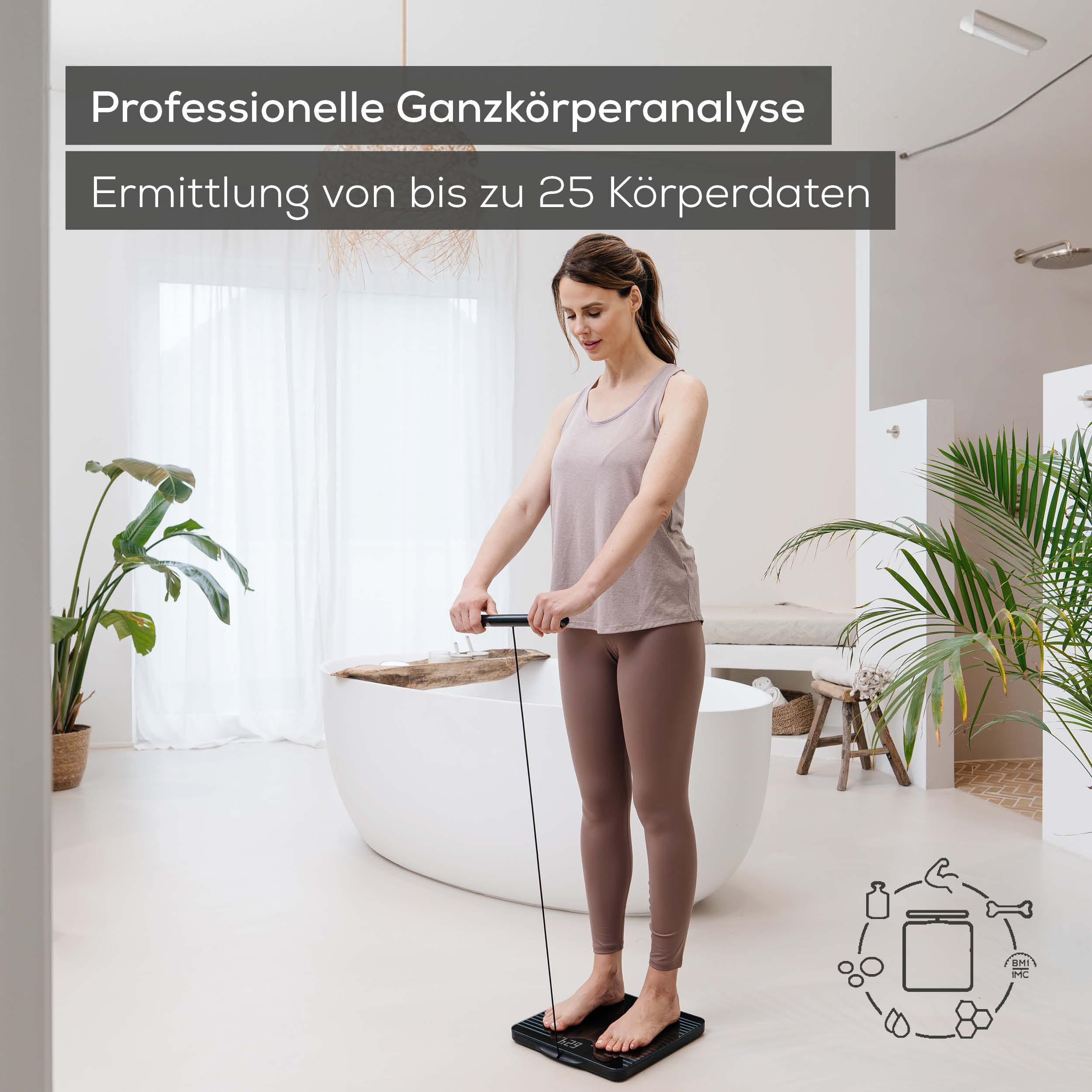 Frau auf Körperwaage mit Griff, im Badezimmer mit Pflanzen und Wanne.