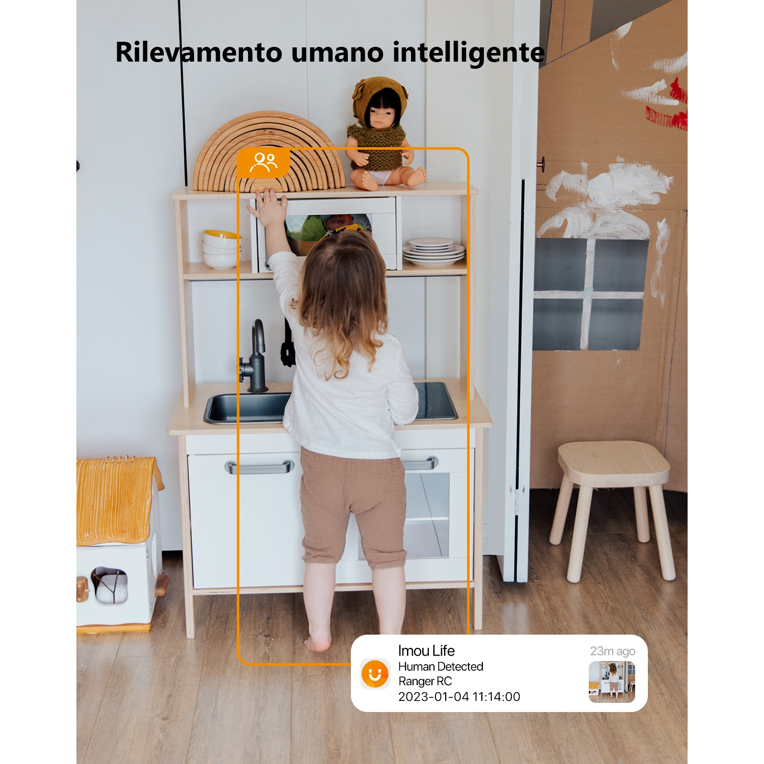 Un bambino gioca in una cucina giocattolo. Una bambola seduta sopra.