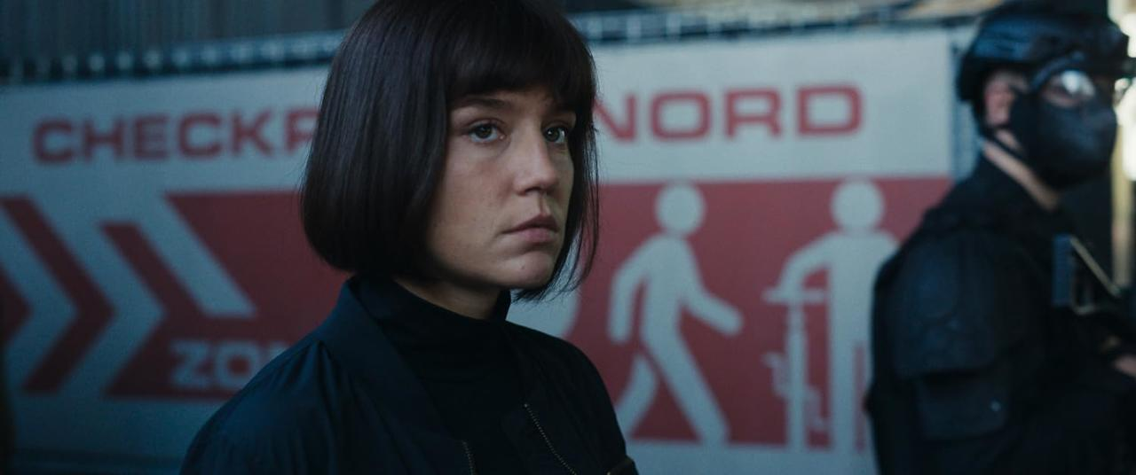 Eine Frau mit Bob-Schnitt steht vor einem Schild mit der Aufschrift NORD.