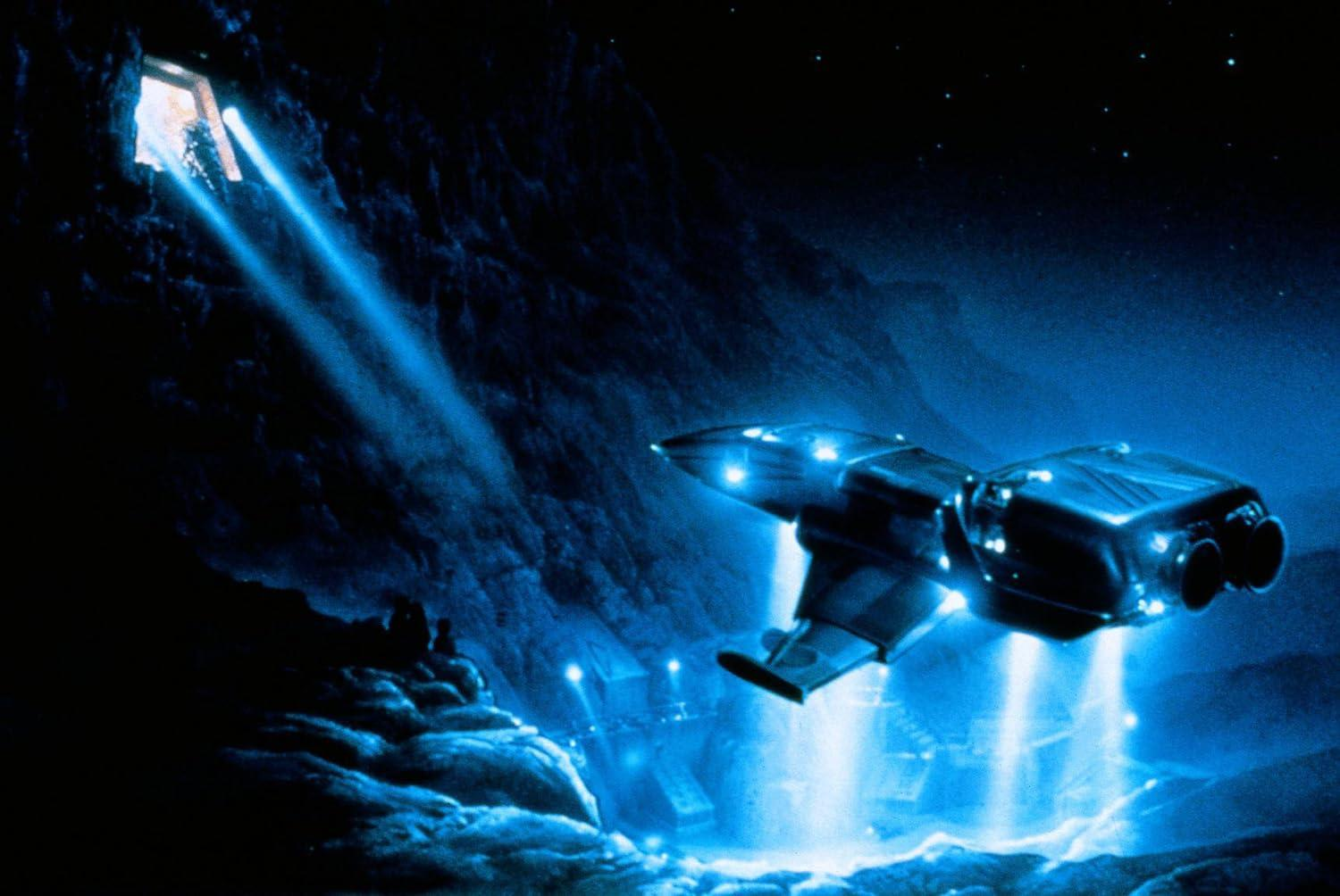 Ein Raumschiff fliegt durch eine dunkle Höhle, beleuchtet von blauen Lichtern.