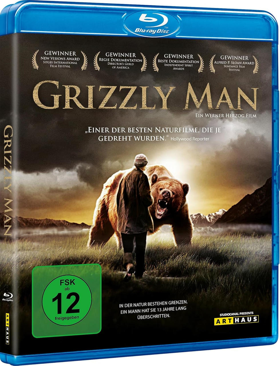 Ein Mann und ein Grizzlybär stehen sich in einer Wiese gegenüber. Filmcover.