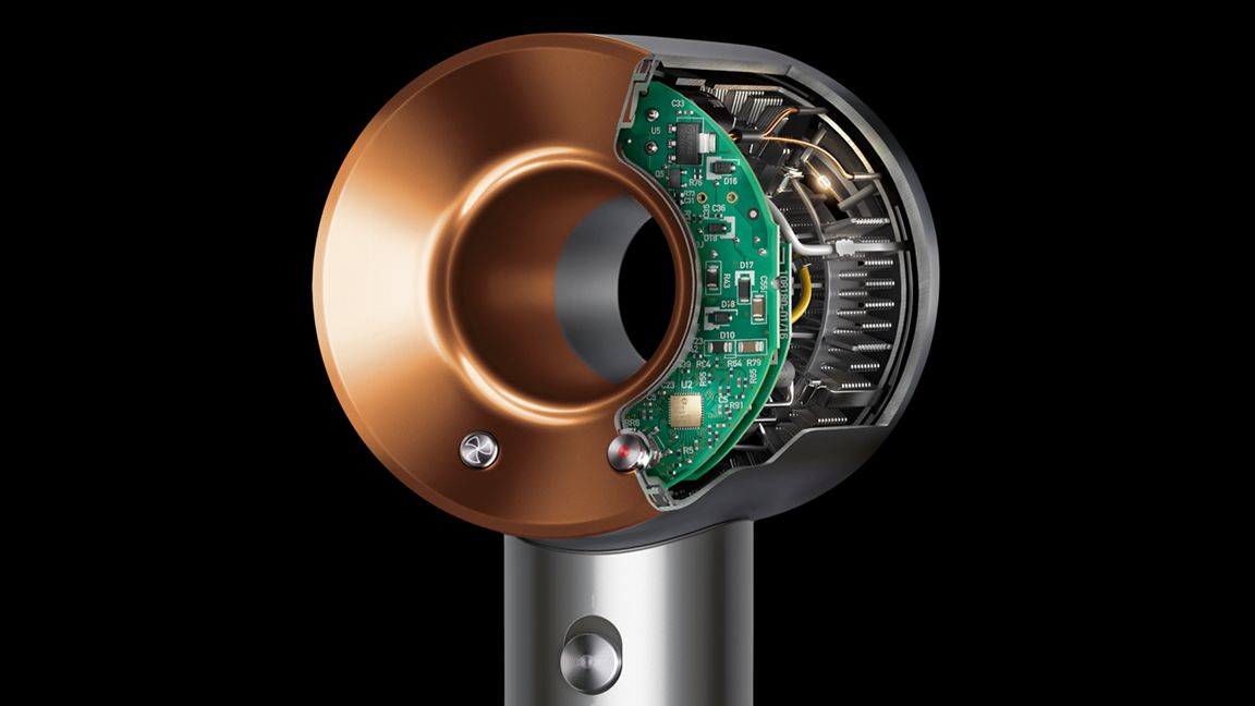 Une vue éclatée d'un sèche-cheveux Dyson Supersonic, révélant ses circuits internes et ses composants sur fond noir.