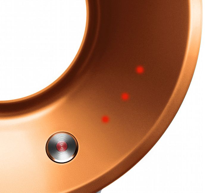 Gros plan d'un anneau de couleur bronze avec un bouton métallique à centre rouge et trois voyants rouges.