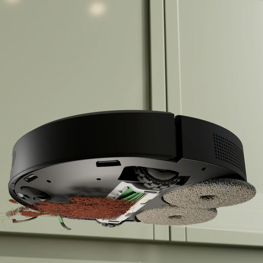 Unterseite eines schwarzen Roboterstaubsaugers mit braunem Staub und zwei runden Wischpads vor hellgrünem Hintergrund.