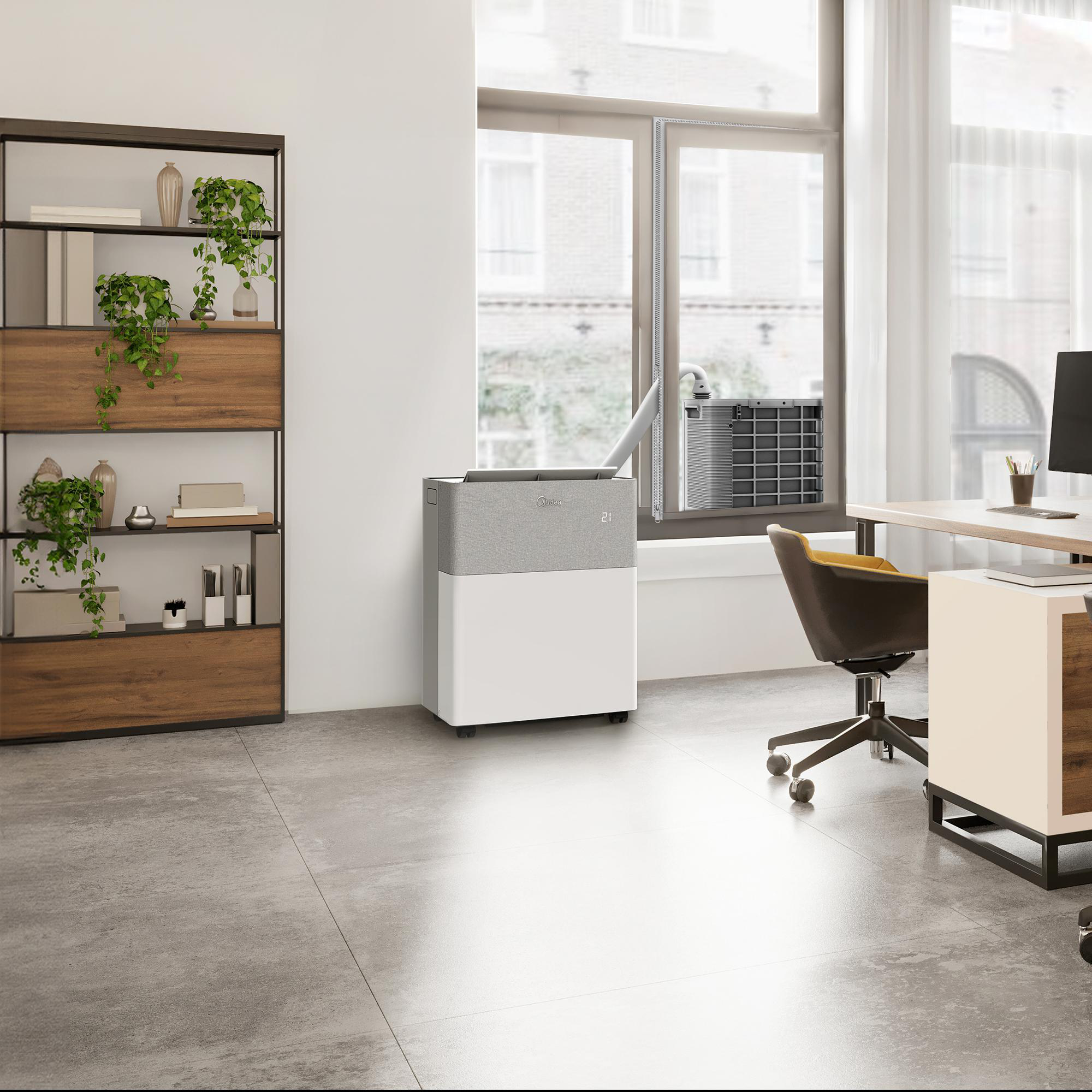 Ein modernes Büro mit einer weiß-grauen mobilen Klimaanlage, einem Holzregal mit Pflanzen und einem Schreibtisch mit Stuhl.